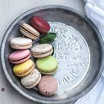 Une assiette de macarons sur une table en bois.