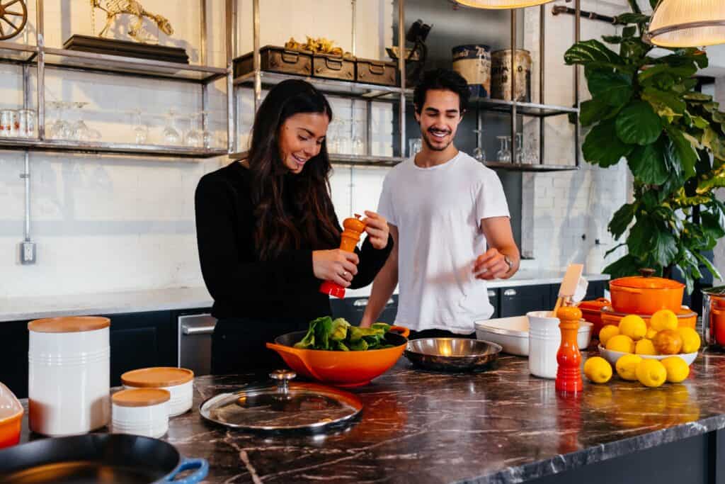Un homme et une femme préparent un repas dans une cuisine.